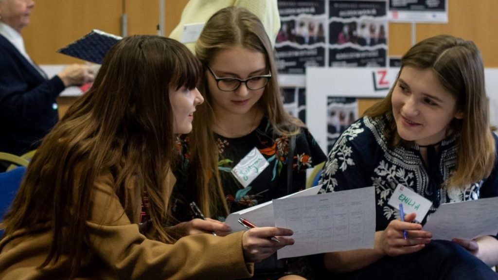 troje dzieci z białymi kartkami w ręku