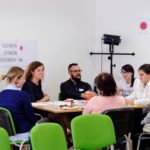 osiem osób rozmawia przy stole