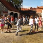 Duża grupa dzieci biega w kręgu dobrze się bawiąc.