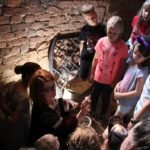 Kobieta pokazuje mały flakon grupie dzieci.