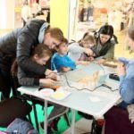 dzieci sklejają małe drewniane elementy pistoletem do sylikonu