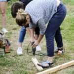 kobieta wkręca wiertarką wkręt do drewnianego elementu