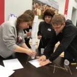 piramida z plastikowych kubków i białych kartek zwiniętych w rulon