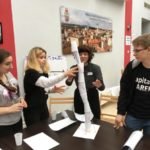 piramida z plastikowych kubków i białych kartek zwiniętych w rulon