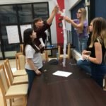 piramida z plastikowych kubków i białych kartek zwiniętych w rulon